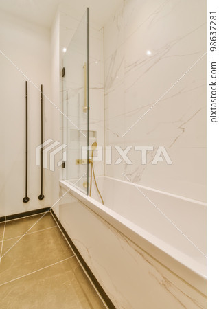 a modern bathroom with marble flooring and white walls, along with a large bathtub next to the tub a modern bathroom with marble flooring and white walls, along with a large bathtub next to the tub 98637281