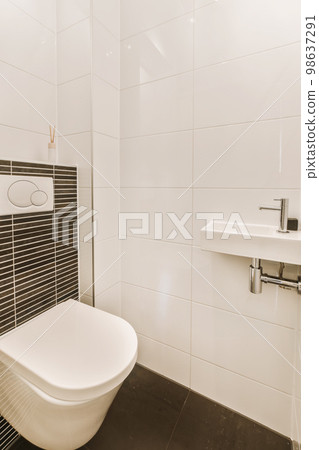 a modern bathroom with black and white tiles on the walls, toilet and sink in the room is clean and ready to use 98637291
