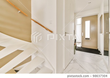 an interior with marble flooring and white staircase leading up to the second floor there is a mirror on the wall 98637304