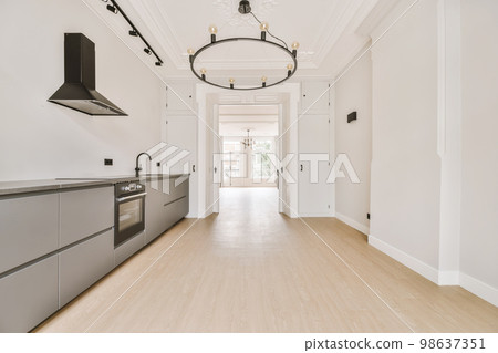 an empty kitchen with white walls and light wood flooring in the center of the room is a chandel an empty kitchen with white walls and light wood flooring in the center of the room is a chandel 98637351