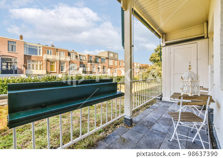 a balcony with white railings and blue sky in the background there is a green bench on the right hand side a balcony with white railings and blue sky in the background there is a green bench on the right hand side 98637390