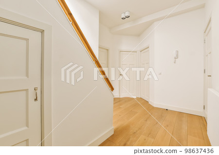an empty room with white walls and wood flooring the door is in front of the wall to the right an empty room with white walls and wood flooring the door is in front of the wall to the right 98637436