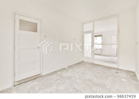 an empty room with white walls and no one door on the other wall there is a mirror in the corner 98637459