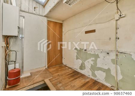 an unfinished room with wood flooring and white paint on the walls, in which is being used for painting 98637460