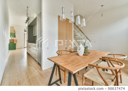 Interior of the dining area next to the stairs to the top and a vase of flowers on the table 98637474