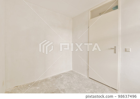 an empty room with white walls and no one door on the other wall there is a small window in the corner 98637496