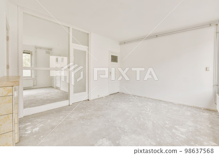 an empty room with white walls and mirrors on the wall, in which is being used as a dressing area 98637568