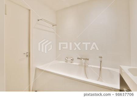 a bathroom with a sink and mirror in the corner next to the bathtub is white tiles on the wall 98637706