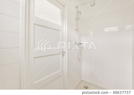 a bathroom with white tiles on the floor and shower stall door open to show how it's supposed to be 98637737