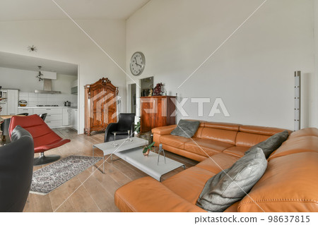 a living room with orange leather couches and an old clock on the wall in the room is very clean a living room with orange leather couches and an old clock on the wall in the room is very clean 98637815