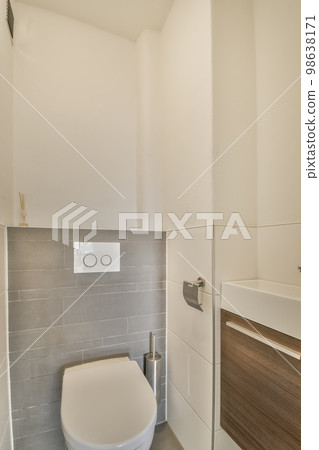 a modern bathroom with white walls and grey tiles on the wall, there is a toilet in the corner next to the sink 98638171