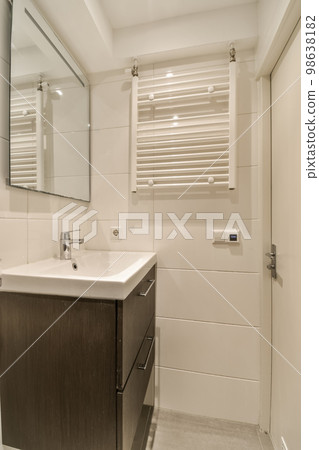a bathroom with a sink, mirror and toilet paper dispensed on the wall next to the vanity a bathroom with a sink, mirror and toilet paper dispensed on the wall next to the vanity 98638182