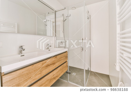 Sinks with mirrors and shower box with glass door in modern bathroom with white tiled walls 98638188