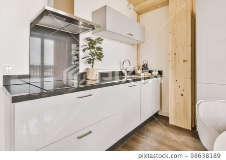 Home interior design of modern loft apartment with open kitchen in minimalist style and spacious dining zone with table and chairs 98638189