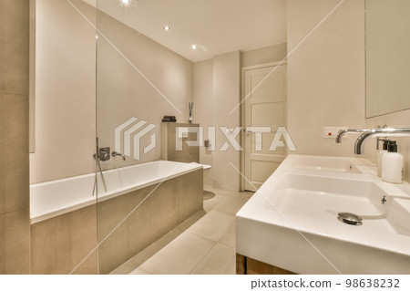 a bathroom with a sink and bathtub in the middle part of the room there is a mirror on the wall a bathroom with a sink and bathtub in the middle part of the room there is a mirror on the wall 98638232