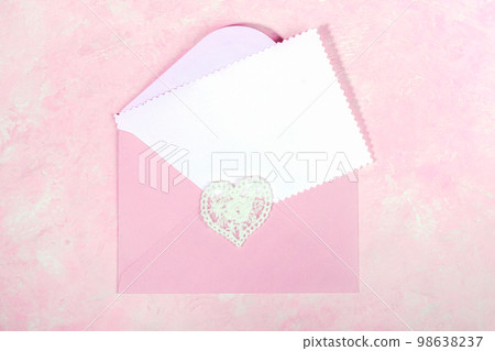 Pink envelope with lace heart and empty white blank sheet for text on pink. Top view. Close up. 98638237