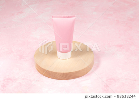 Pink blank cosmetic tube standing on wooden slice on pink background. Mock up. Copy space. Pink blank cosmetic tube standing on wooden slice on pink background. Mock up. Copy space. 98638244