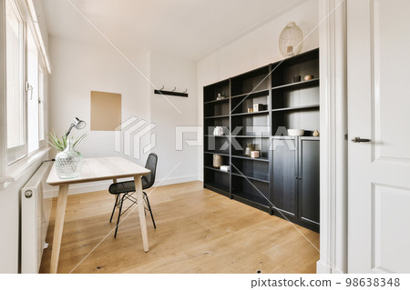 a room with a desk, chair and bookcases on the wall next to an open door that leads to a window a room with a desk, chair and bookcases on the wall next to an open door that leads to a window 98638348