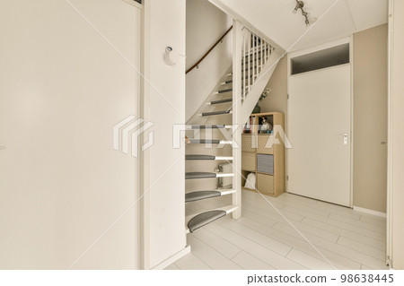 a white room with stairs and shelves on the wall next to an open door that leads to a small hallway a white room with stairs and shelves on the wall next to an open door that leads to a small hallway 98638445