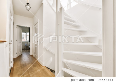 a white staircase with wood flooring and wooden handrails in a home interior photo taken from the front door a white staircase with wood flooring and wooden handrails in a home interior photo taken from the front door 98638553