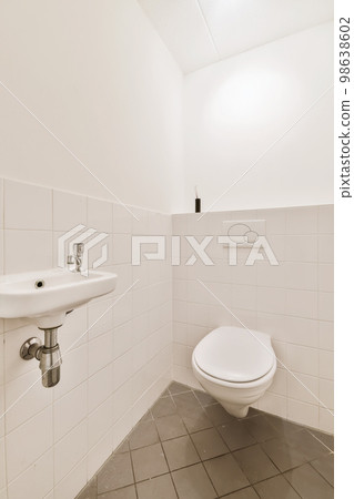 a bathroom with a sink and toilet paper dispensed on the wall next to it is a mirror 98638602