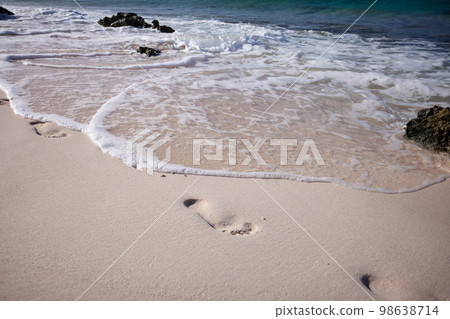 Gentle wave washed away the footprints on the sand beach. Gentle wave washed away the footprints on the sand beach. 98638714