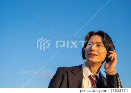 戴耳機聽音樂的高中生英語聽力製服西裝外套藍天訂閱 98638874