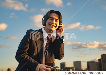 高中生戴耳機聽音樂英語聽力製服西裝外套藍天訂閱智能手機樂趣 98638877