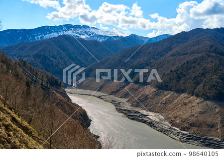 A mountainous landscape with a large dewatered mountain river 98640105
