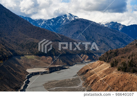 A mountainous landscape with a large dewatered mountain river 98640107