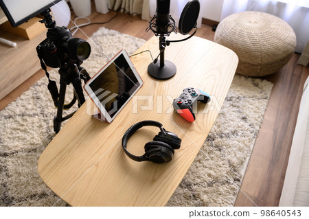 Arranging the equipment for game distribution Tablet, microphone and controller headphones YouTuber playing the game 98640543