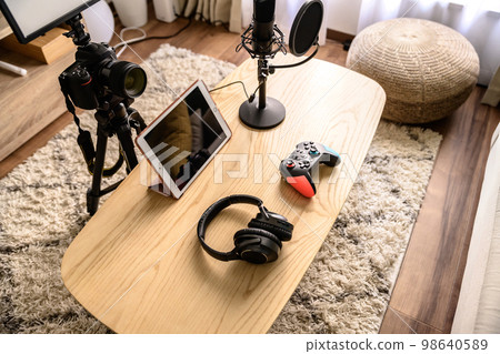 Arranging the equipment for game distribution Tablet, microphone and controller headphones YouTuber playing the game Arranging the equipment for game distribution Tablet, microphone and controller headphones YouTuber playing the game 98640589