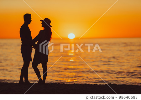 Young couple on white beach during summer vacation at sunset. PHOTO OUT OF FOCUS Young couple on white beach during summer vacation at sunset. PHOTO OUT OF FOCUS 98640685