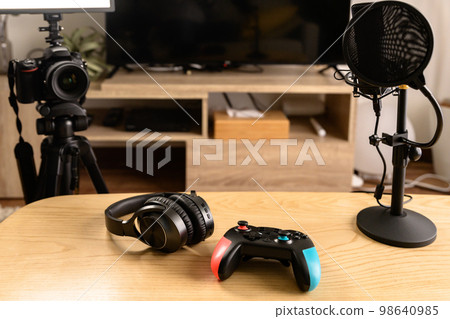 Arranging the equipment for game distribution Single-lens reflex camera, microphone and controller headphones YouTuber playing the game Arranging the equipment for game distribution Single-lens reflex camera, microphone and controller headphones YouTuber playing the game 98640985