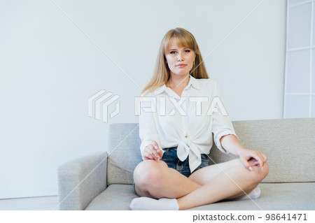 a woman in home style relaxes on the sofa at home a woman in home style relaxes on the sofa at home 98641471