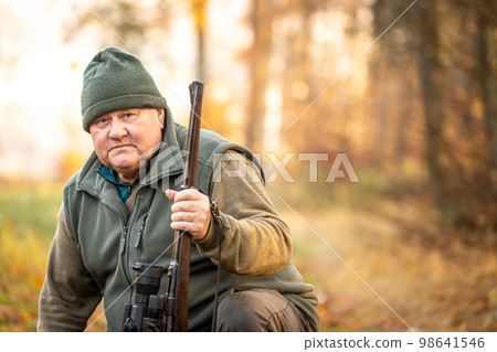 Portrait of hunter or ranger with a hunting gun and hunting form to hunt in an autumn forest, hunting concept 98641546