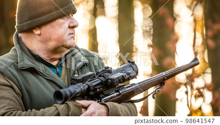 Portrait of hunter or ranger with a hunting gun and hunting form to hunt in an autumn forest, hunting concept Portrait of hunter or ranger with a hunting gun and hunting form to hunt in an autumn forest, hunting concept 98641547