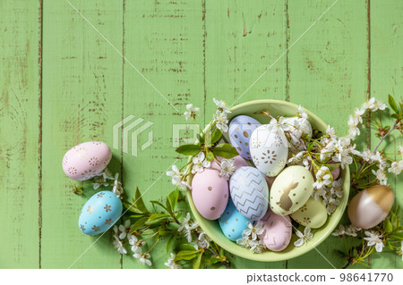 Easter composition. Branches of a blooming apple tree, handmade Easter colorful eggs on a pastel rustic wooden table. Happy Easter Holidays. View from above. Copy space. Easter composition. Branches of a blooming apple tree, handmade Easter colorful eggs on a pastel rustic wooden table. Happy Easter Holidays. View from above. Copy space. 98641770
