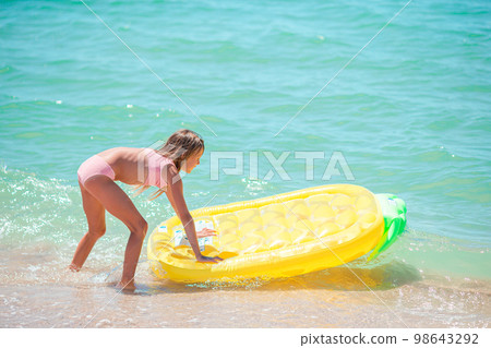 Little happy girl with inflatable air mattress in the sea having fun Little happy girl with inflatable air mattress in the sea having fun 98643292