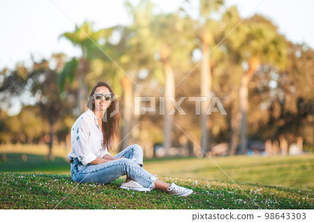 Portrait of happy young woman outdoor in the park at sunset 98643303
