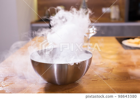 Smoke vapor dry ice in bowl in kitchen Smoke vapor dry ice in bowl in kitchen 98643380