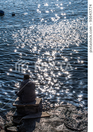 Man sitting and contemplating on beach. Concept of freedom relaxation. Man sitting and contemplating on beach. Concept of freedom relaxation. 98643774