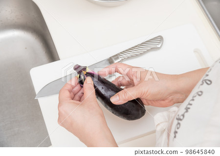 [Cut the stem of the eggplant with a Santoku knife] 98645840