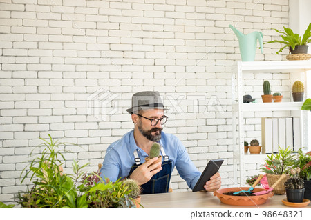 An elderly man handsome with have mustache wearing glasses is happy with tree care. is a hobby of gardening at home, living happily after retirement. Concepts nature and environment 98648321