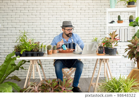 An elderly man handsome with have mustache wearing glasses is happy with tree care. is a hobby of gardening at home, living happily after retirement. Concepts nature and environment An elderly man handsome with have mustache wearing glasses is happy with tree care. is a hobby of gardening at home, living happily after retirement. Concepts nature and environment 98648322