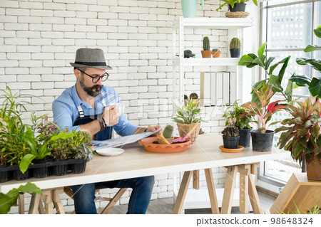 An elderly man handsome with have mustache wearing glasses is happy with tree care. is a hobby of gardening at home, living happily after retirement. Concepts nature and environment An elderly man handsome with have mustache wearing glasses is happy with tree care. is a hobby of gardening at home, living happily after retirement. Concepts nature and environment 98648324