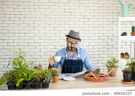 An elderly man handsome with have mustache wearing glasses is happy with tree care. is a hobby of gardening at home, living happily after retirement. Concepts nature and environment An elderly man handsome with have mustache wearing glasses is happy with tree care. is a hobby of gardening at home, living happily after retirement. Concepts nature and environment 98648325