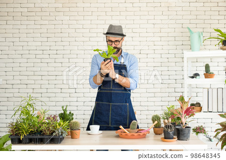 An elderly man handsome with have mustache wearing glasses is happy with tree care. is a hobby of gardening at home, living happily after retirement. Concepts nature and environment An elderly man handsome with have mustache wearing glasses is happy with tree care. is a hobby of gardening at home, living happily after retirement. Concepts nature and environment 98648345