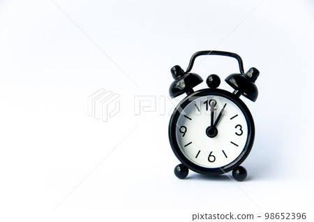 Black alarm clock pointing at 1 o'clock with customizable space for text on white background. Copy space. 98652396