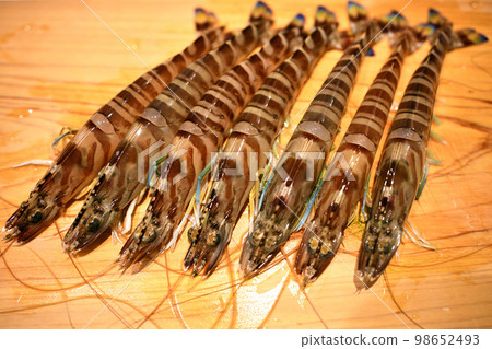 Live tiger prawns on cutting board Live tiger prawns on cutting board 98652493